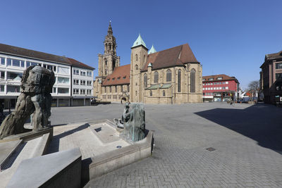 View of sculpture against buildings in city