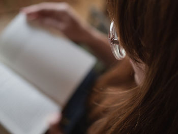 Close-up of woman reading book at home