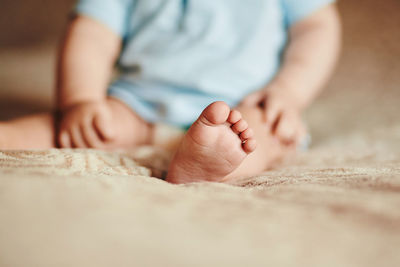 Close-up of baby hand on bed