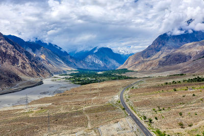 Scenic view of road by mountains against sky