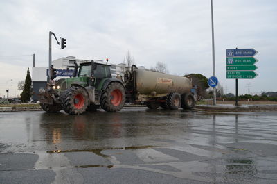 Agricultural vehicle on road against sky