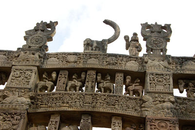 Low angle view of statue against historic building against sky