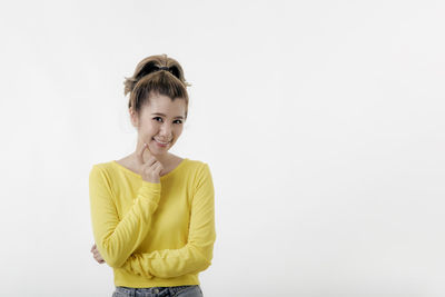 Portrait of a smiling young woman against white background