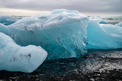 Close-up of glacier on sea against sky