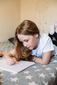 Girl drawing on paper at home