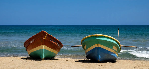 Deck chairs on beach against clear sky