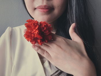 Close-up of woman with red flowers