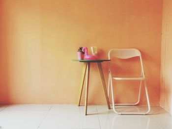 Empty chairs and table against wall at home