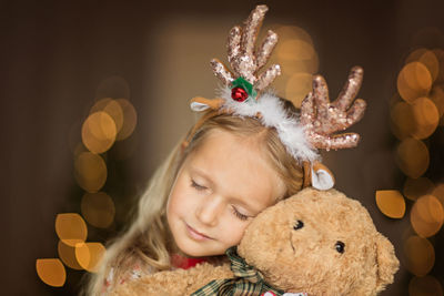 Close-up of cute girl embracing stuffed toy at home