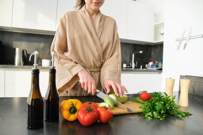 Midsection of young woman standing at home