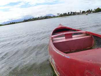 Boat moored on shore against sky