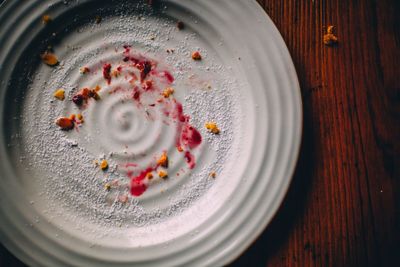 High angle view of leftovers food in plate on wooden table