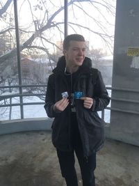 Full length of man using phone while standing in winter