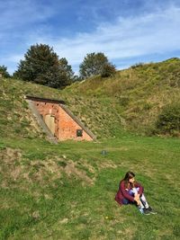 Rear view of man sitting on grassy field