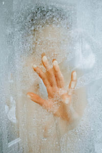 Close-up of hand touching water in bathroom