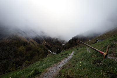 Road amidst green landscape against sky