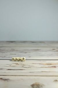 Close-up of coins on table against sea
