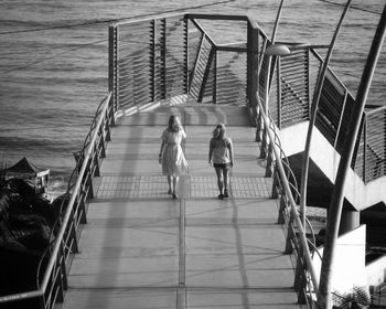 Rear view of people on pier over sea