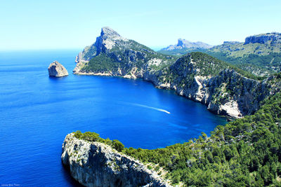 Panoramic view of sea and mountains against clear blue sky