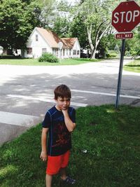 Full length of boy standing by road against building