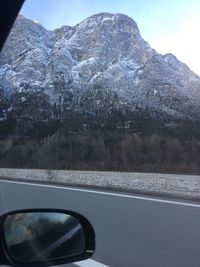 Close-up of car on road against mountain range