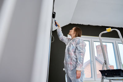 Rear view of woman standing by railing