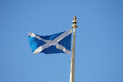 Low angle view of flag pole against clear blue sky