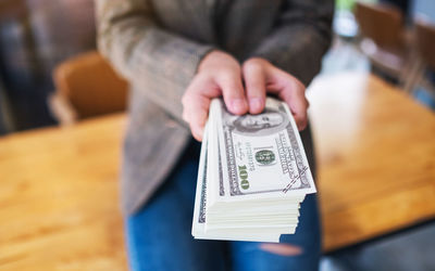 Midsection of woman holding paper currency