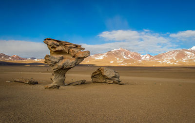 Rock formations on landscape against blue sky