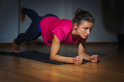 Full length of woman exercising on floor