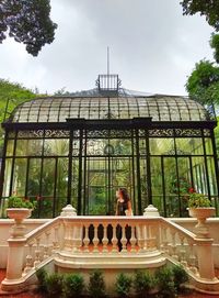 People sitting by swimming pool against sky