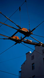 Low angle view of telephone pole against clear blue sky