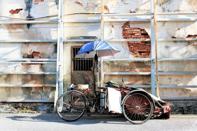 Parked trishaw against rustic painted wall