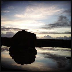 Reflection of clouds in sea at sunset