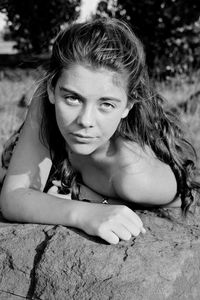 Portrait of teenage girl lying on rock