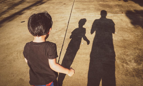 Rear view of boy standing on street