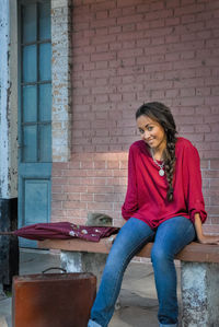 Woman sitting against wall