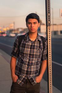 Portrait of young man standing in city