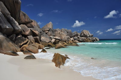 Rock formations on shore against sky