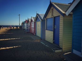 Beach huts against clear blue sky
