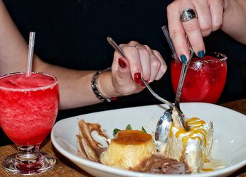 Midsection of woman holding ice cream on table