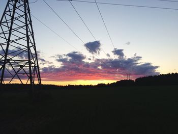 Silhouette of electricity pylon at sunset