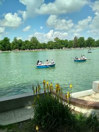 People on lake against sky