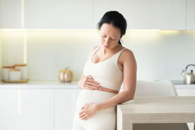 Side view of young woman standing at home