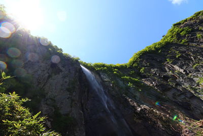 Low angle view of waterfall against sky