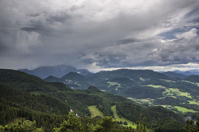 High angle view of trees on mountains in valley against cloudy sky