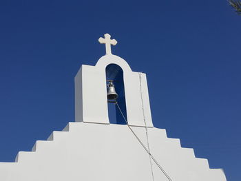 Low angle view of bell tower of church against clear blue sky at santorini