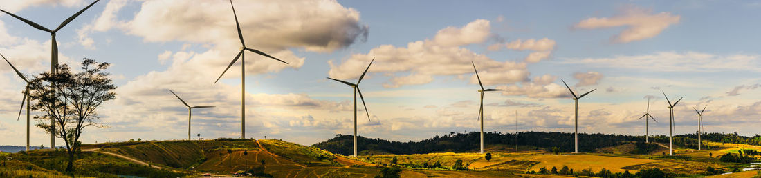 Panoramic view of wind turbine on field against sky