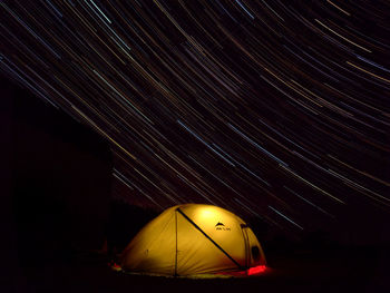 Low angle view of illuminated tent against sky at night