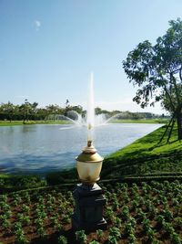 Fountain by sea against clear sky